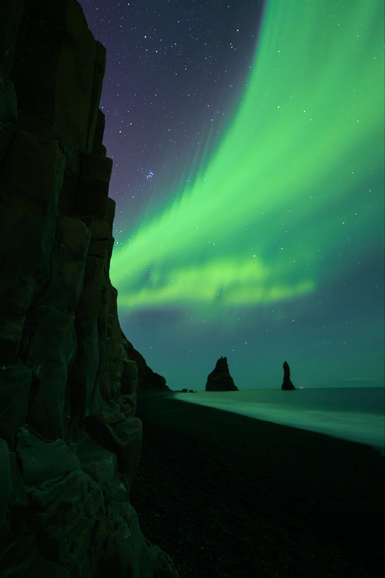 Aurora over a black sand beach
